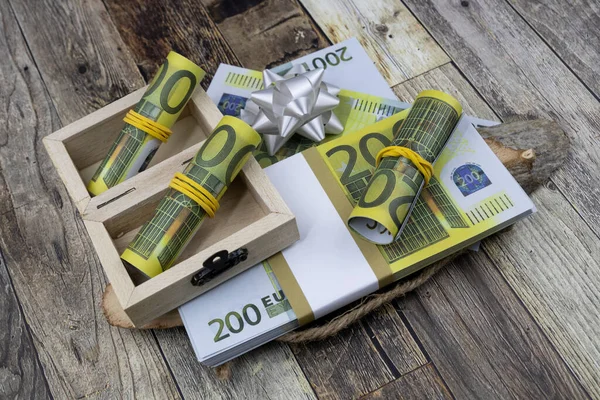 Billets de 200 euros enroulés dans de petites boîtes en bois sur un paquet de billets — Photo