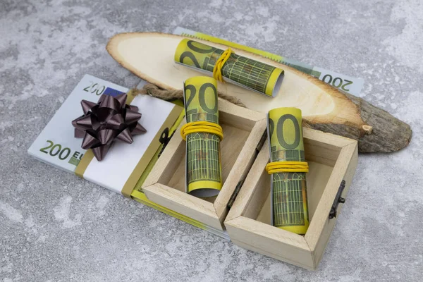 Um pacote de 200 notas de euro em pequenas caixas de madeira e em cortes de madeira decorativos — Fotografia de Stock