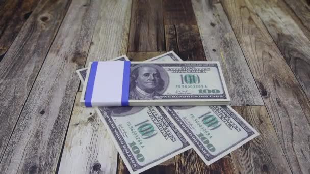 Guante de mano pone un cubo de billetes de 100 dólares en un sobre con billetes — Vídeo de stock