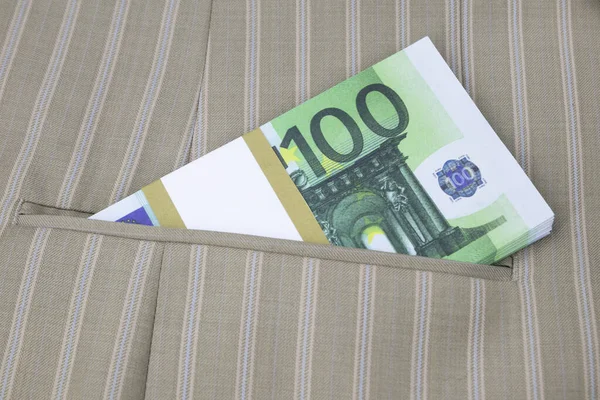 Un paquet de 100 billets en euros dans la poche d'une veste rayée — Photo