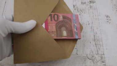 Beyaz bir eldiven verin. Masaya 10 Euro 'luk bir zarf koyun.