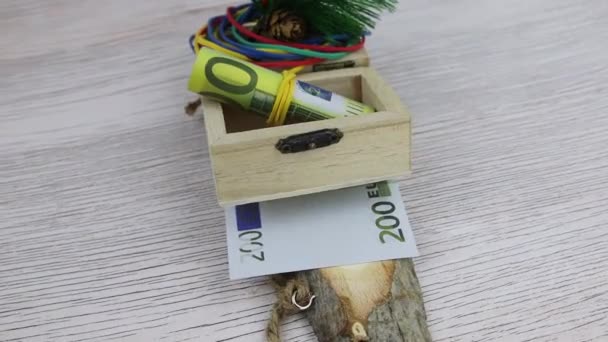 작은 나무 상자에 적혀 있는 200 유로짜리 지폐를 선물로 받은 크리스마스 선물 — 비디오