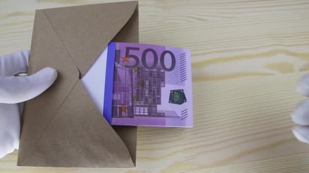 La mano en un guante blanco cuenta con un paquete de billetes de 500 euros en un sobre marrón — Vídeo de stock