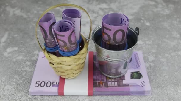 Ręka z rękawicą zabiera 500 banknotów euro z małym koszykiem i wiadrem — Wideo stockowe