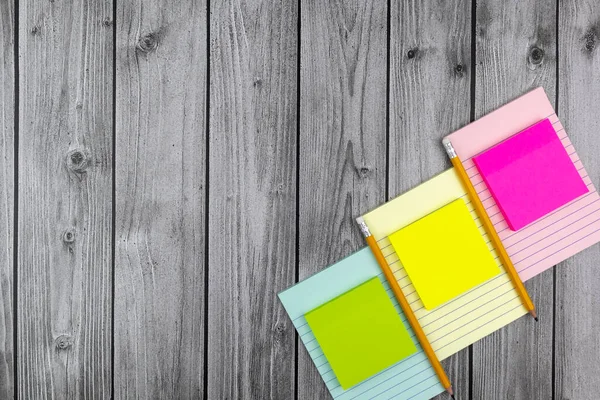 Colorful memo pads with matching notebooks and copyspace. Flat lay, top view