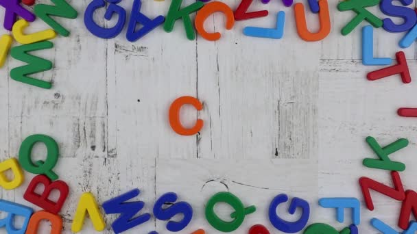 Letras do alfabeto coloridas que emolduram a palavra. Stop motion, vista superior — Vídeo de Stock