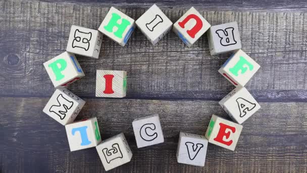 Word - Ikon színes ábécé betűkkel fa kockákon. Állj, felülnézet! — Stock videók