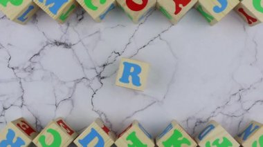 Tahta küplerde renkli alfabe harfleri olan sanat konsepti. Hareketi durdur