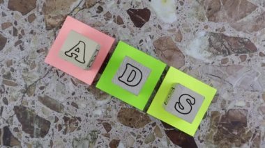 Alfabe harfli ahşap küplerle AIDS konsepti. Döndürme