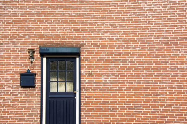 Porte sur mur de briques, côté d'une maison — Photo