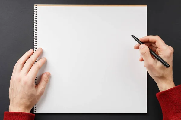 Cuaderno con pluma negra en las manos —  Fotos de Stock