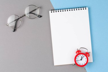 Mavi üzerinde kırmızı alarm saati olan defter