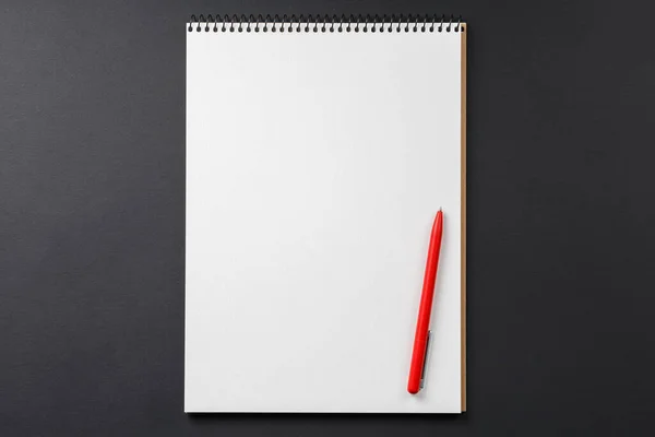 Cuaderno con pluma roja sobre fondo negro — Foto de Stock