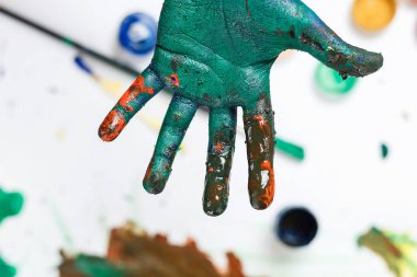 Çocuk okulda elleriyle resim çiziyor.