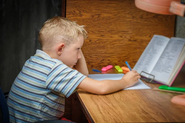 家で一生懸命宿題をしている少年は — ストック写真