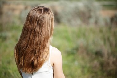 Kız tarlada sırtüstü duruyor.