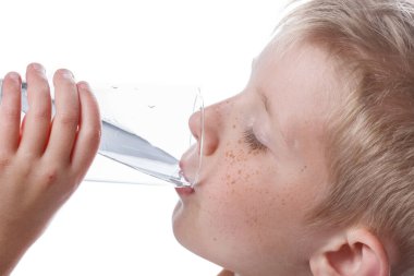 Küçük çocuk bardaktan temiz su içer.