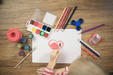 Kağıt üzerinde renkli kalemlerle sevimli çocuk resimleri.