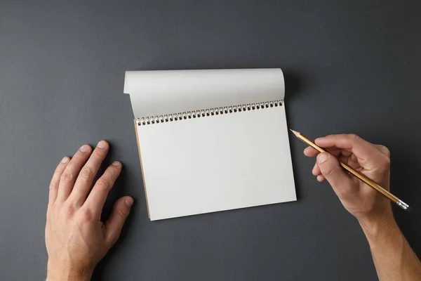 Otwarty notatnik i męskie dłonie trzymające ołówek. — Zdjęcie stockowe