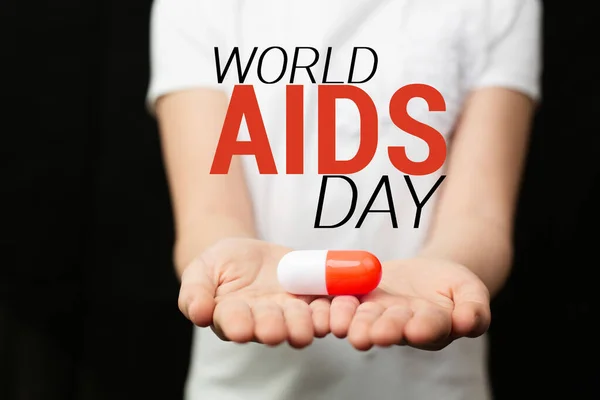 Meisje houdt een speelgoed pil Wereld AIDS Dag Concept. — Stockfoto