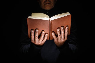 Ellerinde kitabı aç.