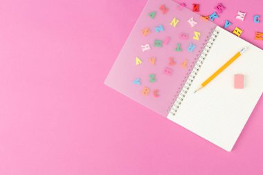 Masanın üzerinde kırtasiye malzemesi olan sarmal not defteri..