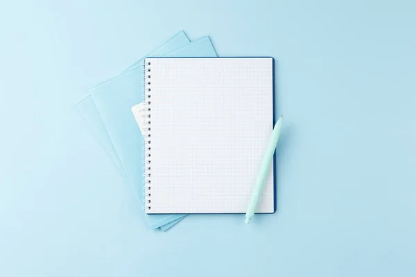 Caderno com lápis sobre mesa azul. — Fotografia de Stock