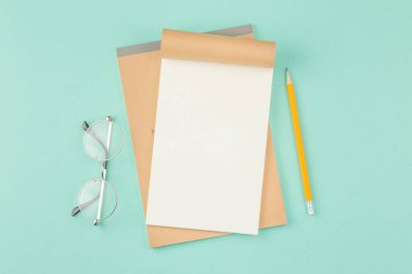 Okul defterini kalemle aç.