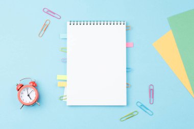 Mavi zemin üzerinde kırtasiye malzemesi olan okul not defteri.