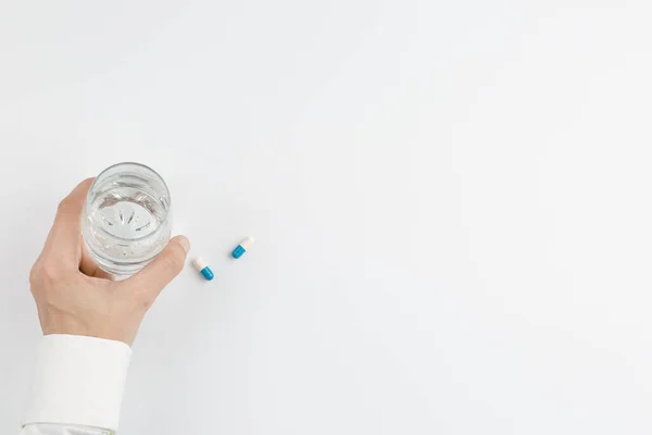 Kéz pohár víz és tabletta fehér háttér — Stock Fotó