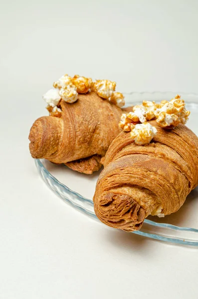 Croissants com pipoca em uma travessa — Fotografia de Stock