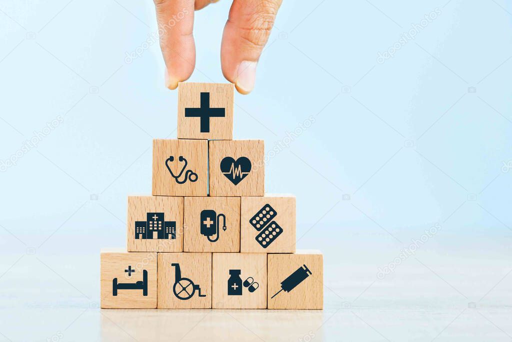 Health insurance concept, hand arranging wood block stacking with icon healthcare medical.