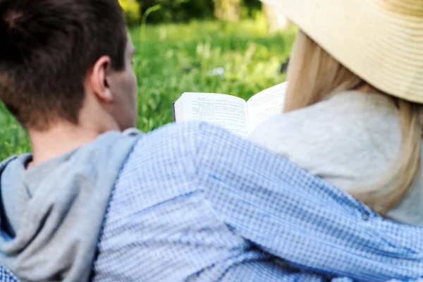 A loving couple reading a book on nature — Stock Photo, Image