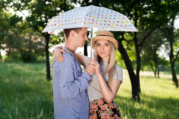 Loving couple standing under an umbrella — Stock Photo, Image