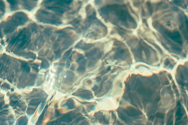 ぼかし効果ソフトフォーカス自然実際の波打つ海の水の表面。要旨背景デザイン壁紙.太陽の下での水中波の日、水のどこビーム。トン写真集｜DARK — ストック写真