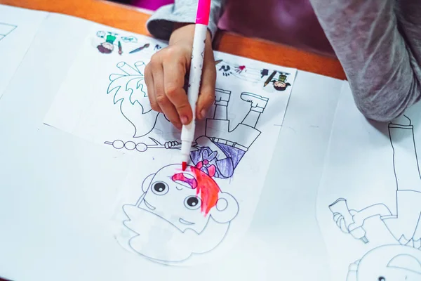 Kleine kind meisje handen, tekening kleurplaat papier pagina 's met roze vilten tip pen. Gelukkige jeugd, thuis en kleuterschool onderwijs, verbeelding ontwikkeling, kinderen creativiteit — Stockfoto