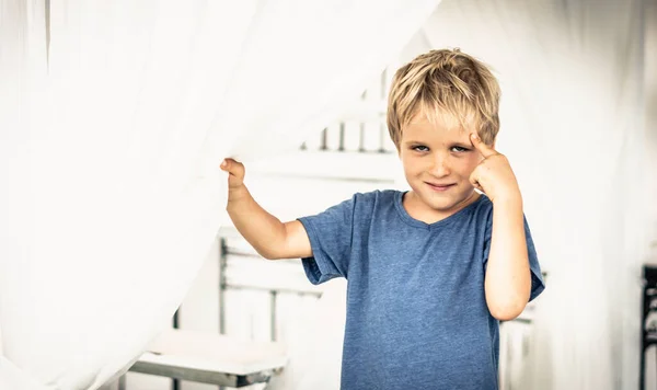 Portrait sly smile narrowed eyes freckled boy points finger to head have idea, facial expression hand gesture. Funny mischievous mood. Happy childhood, behaviour education psychology relationship