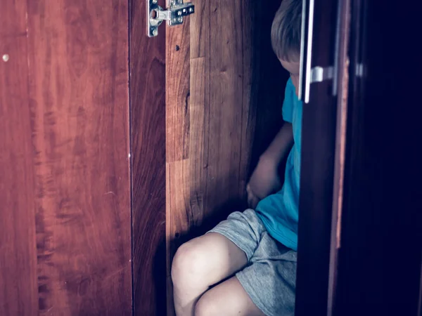 Onherkenbaar Droevige jongen verstoppen zich in kast home garderobe. Kinderemoties. Waarschuwing symptoom teken, behandeling hulp voor jeugd adolescent depressie ziekte, angsten, adoptie gezinsleven problemen — Stockfoto