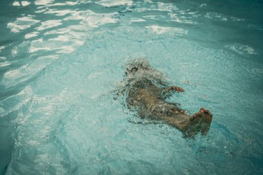 Soyut fotoğraf yaşam tarzı, doğa geçmişi. Suyun altında tanınmayan bir insan vücudu, yüzeye bak. Gizemli bir ruh hali. Ağırlıksız, belirsiz gelecek kavramı, belirsizlik içinde boğulma, çocukluk sorunları