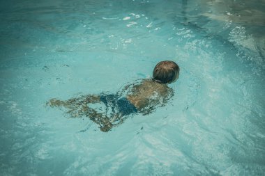 Soyut fotoğraf yaşam tarzı, doğa geçmişi. Suyun altında tanınmayan bir insan vücudu, yüzeye bak. Gizemli bir ruh hali. Ağırlıksız, belirsiz gelecek kavramı, belirsizlik içinde boğulma, çocukluk sorunları