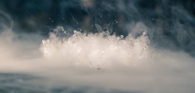 Soyut BANNER. Gerçek Mistik duman bulutu, su damlaları patlaması, buhar uçuşları, karanlık arka plan. Kimyasal deney, aromaterapi, yanık içecek buharı, paranormal sis. Mavi ton. Daha fazla renk kaynağı