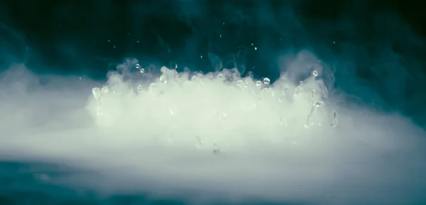 BANNER Abstrak. Awan asap mistik asli dengan ledakan air, gerakan terbang uap, latar belakang gelap. Eksperimen kimia, aromaterapi, membakar uap, kabut paranormal. Nada biru. Stok warna lagi Stok Gambar