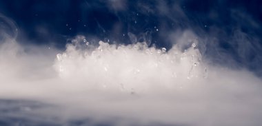 Soyut BANNER. Gerçek Mistik duman bulutu, su damlaları patlaması, buhar uçuşları, karanlık arka plan. Kimyasal deney, aromaterapi, yanık içecek buharı, paranormal sis. Mavi ton. Daha fazla renk kaynağı