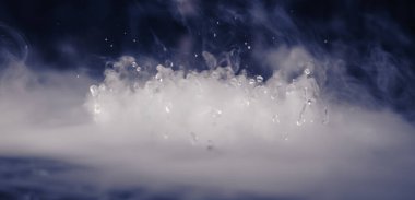 Soyut BANNER. Gerçek Mistik duman bulutu, su damlaları patlaması, buhar uçuşları, karanlık arka plan. Kimyasal deney, aromaterapi, yanık içecek buharı, paranormal sis. Mavi ton. Daha fazla renk kaynağı