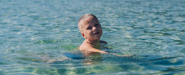 BANNER életmód stock fotó fiú úszni nem mozgás frolics szórakoztató fröccsenő víz tenger. Nyári napfény táj. Boldog gyermekkort, utazás nyaralás gyerekek, szabadidős tevékenység, egyszerű szórakoztató viselkedés — Stock Fotó