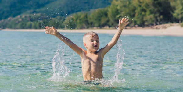 배너 라이프 스킨 (BANNER Lifelife stock boy) 은 헤엄치는 소년 이 물에 튀기는 재밌는 움직임을 보여 주고 있다. 여름 태양의 자연 풍경. 행복 한 어린 시절, 아이들 과 휴가를 보내는 것, 여가 활동, 단순 한 재미있는 행동 — 스톡 사진