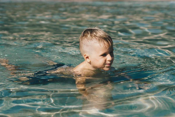 Lifestyle varastossa valokuva poika uida koulutus tehdä liikettä meressä. Kesällä aurinko luonto maisema. Onnellinen lapsuus, matka loma lasten kanssa, vapaa-ajan toiminta, yksinkertainen hauska käyttäytyminen, matkailu — kuvapankkivalokuva