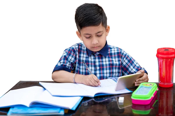 Smiling young male kid using digital smartphone watching online e-learning video to studying in classroom , Asian Indian schoolboy study with Mobile phone. Smiling young male kid using digital smartphone watching online e-learning video to studying i