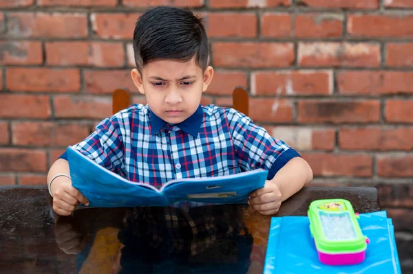 Estudiante Primaria Con Uniforme Escolar Adecuado Leyendo Libro Mesa Estudio — Foto de Stock