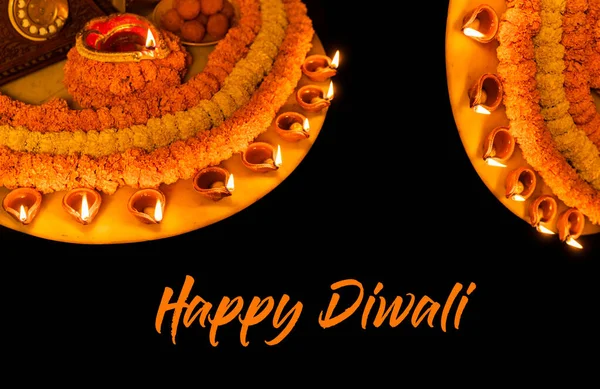 Diwali ışıldayan Diya ve çiçekler daire şeklinde dizilmiş Happy Diwali dileği, seçici odak, Hint festivali ile bir tasarım oluşturuyorlar.